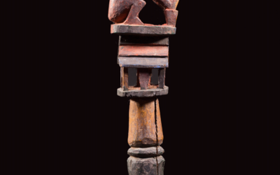 Orsuala (staff) with an achu (jaguar), atop a house.